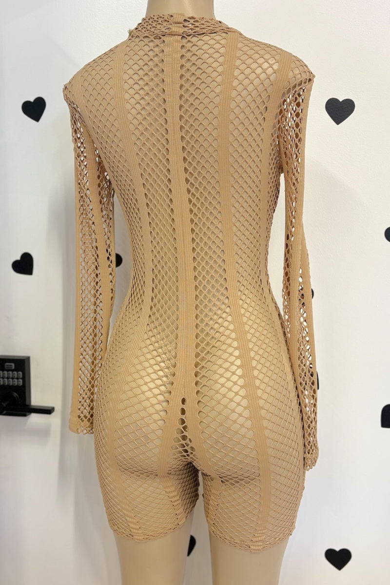 A beige fishnet long-sleeve bodysuit with a high neck and short legs, displayed on a mannequin from the back against a white wall with black heart decorations.