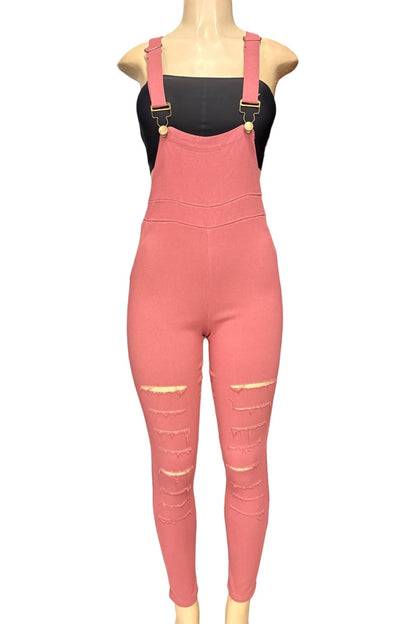 A pink overall-style jumpsuit with shoulder straps and distressed ripped details on the legs, displayed on a mannequin torso against a plain white background.