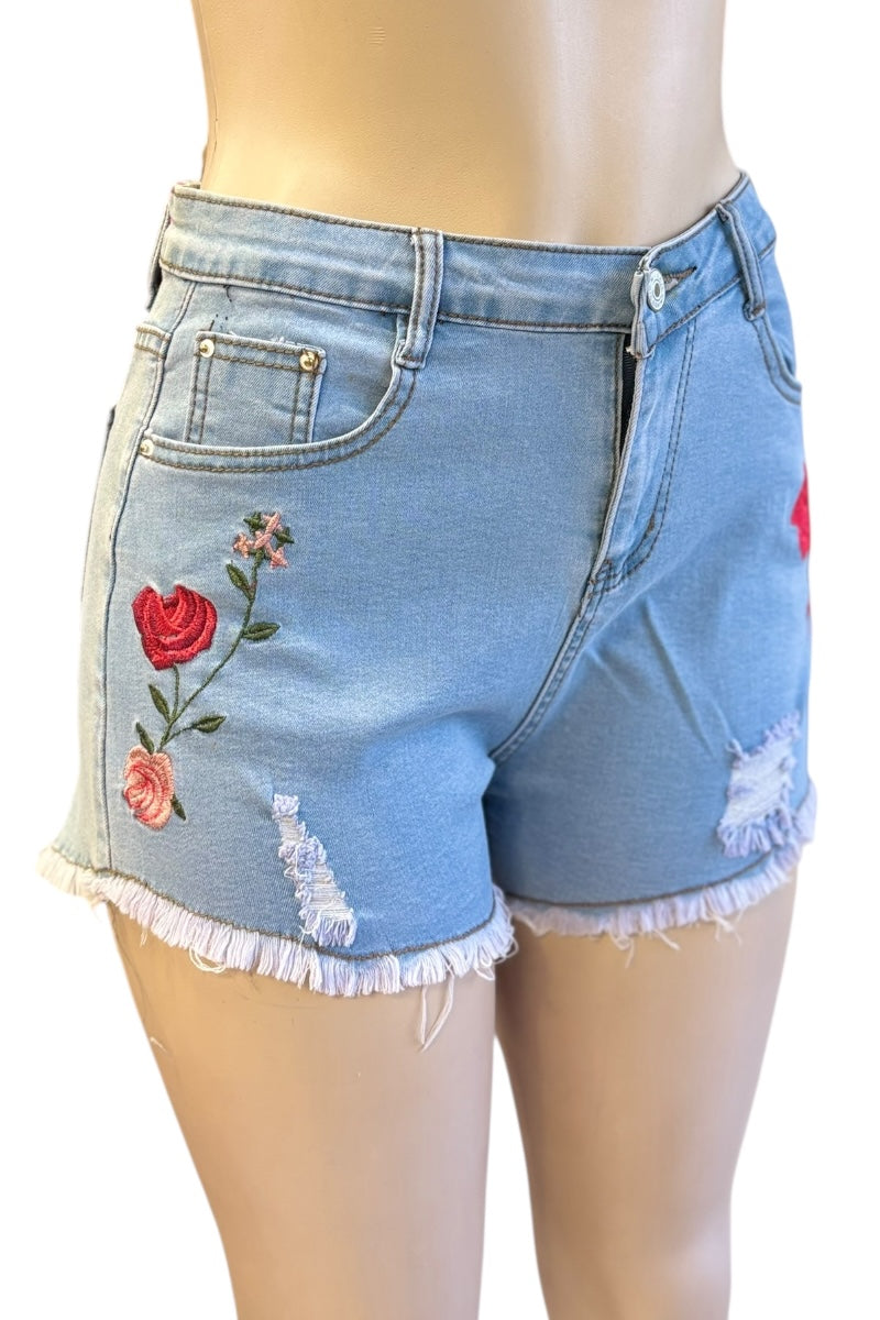 Denim shorts with floral embroidery on a mannequin.