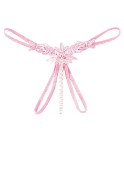 A light pink lace thong with a central floral applique and hanging pearl bead strands, shown on a plain white background.