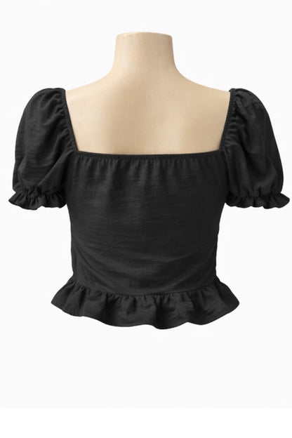 Black top with ruffled sleeves and hem on a mannequin against a white background