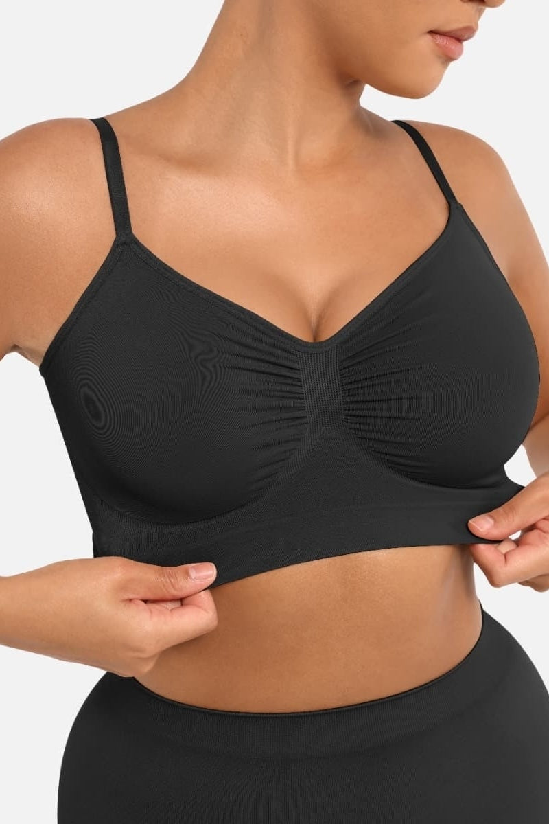 Black sports bra worn by a person on a plain background