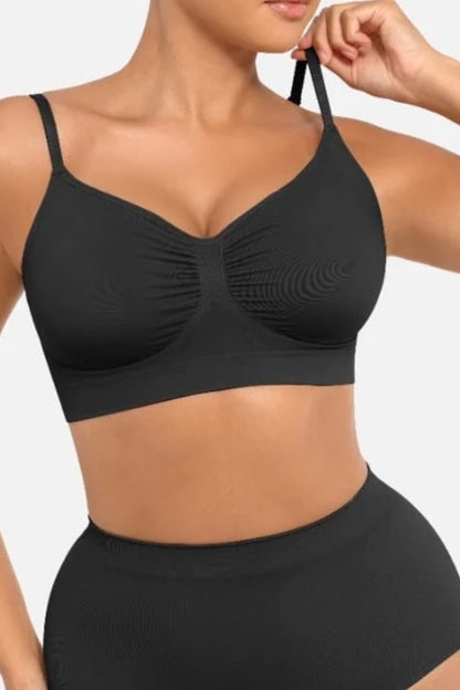 Black bralette worn by a person on a plain background