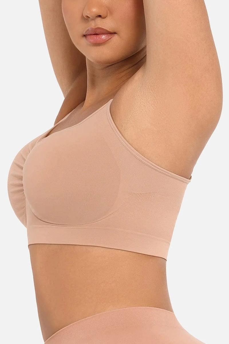 Beige bralette worn by a model on a plain background