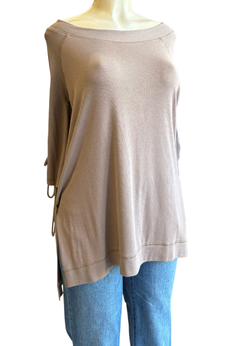 A taupe knit top with a wide boat neckline and side tie details, displayed on a mannequin torso paired with blue jeans against a white background.