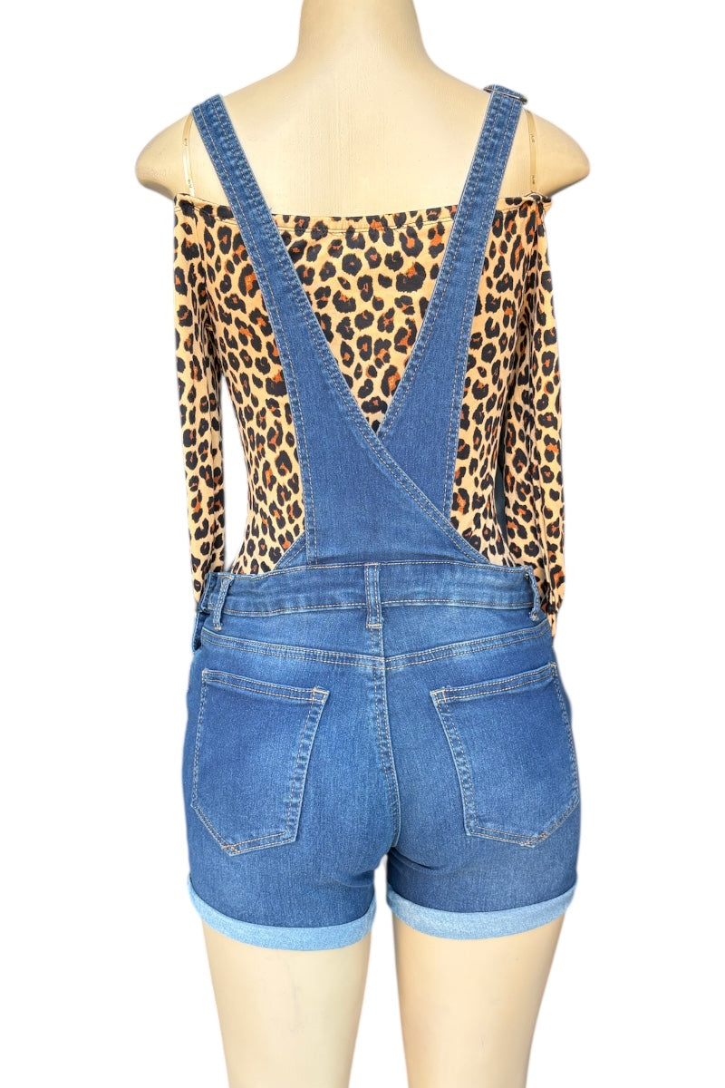 Mannequin wearing leopard print top and blue denim overalls on a white background