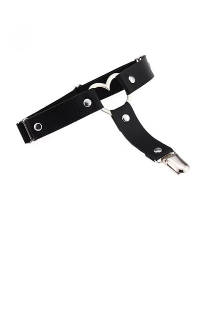 A black faux-leather harness-style belt with silver-tone metal hardware, including rivets, a heart-shaped ring, and a snap hook clasp, shown on a plain white background.