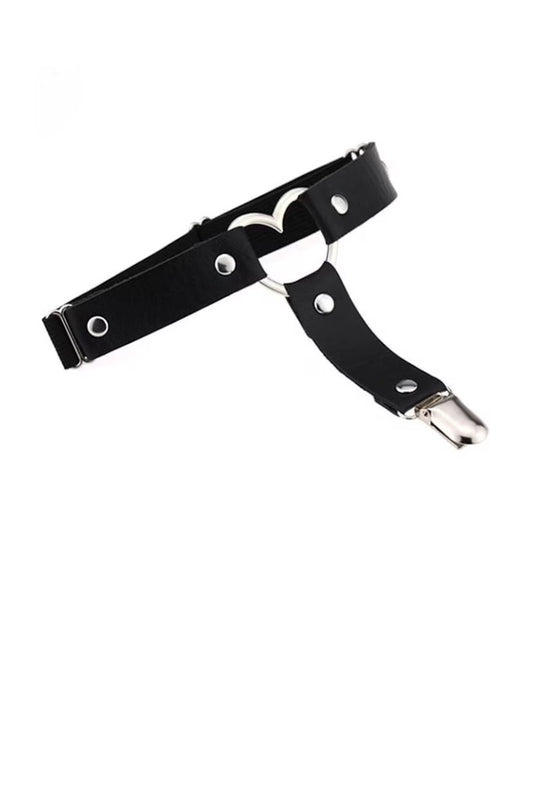 A black faux-leather harness-style belt with silver-tone metal hardware, including rivets, a heart-shaped ring, and a snap hook clasp, shown on a plain white background.