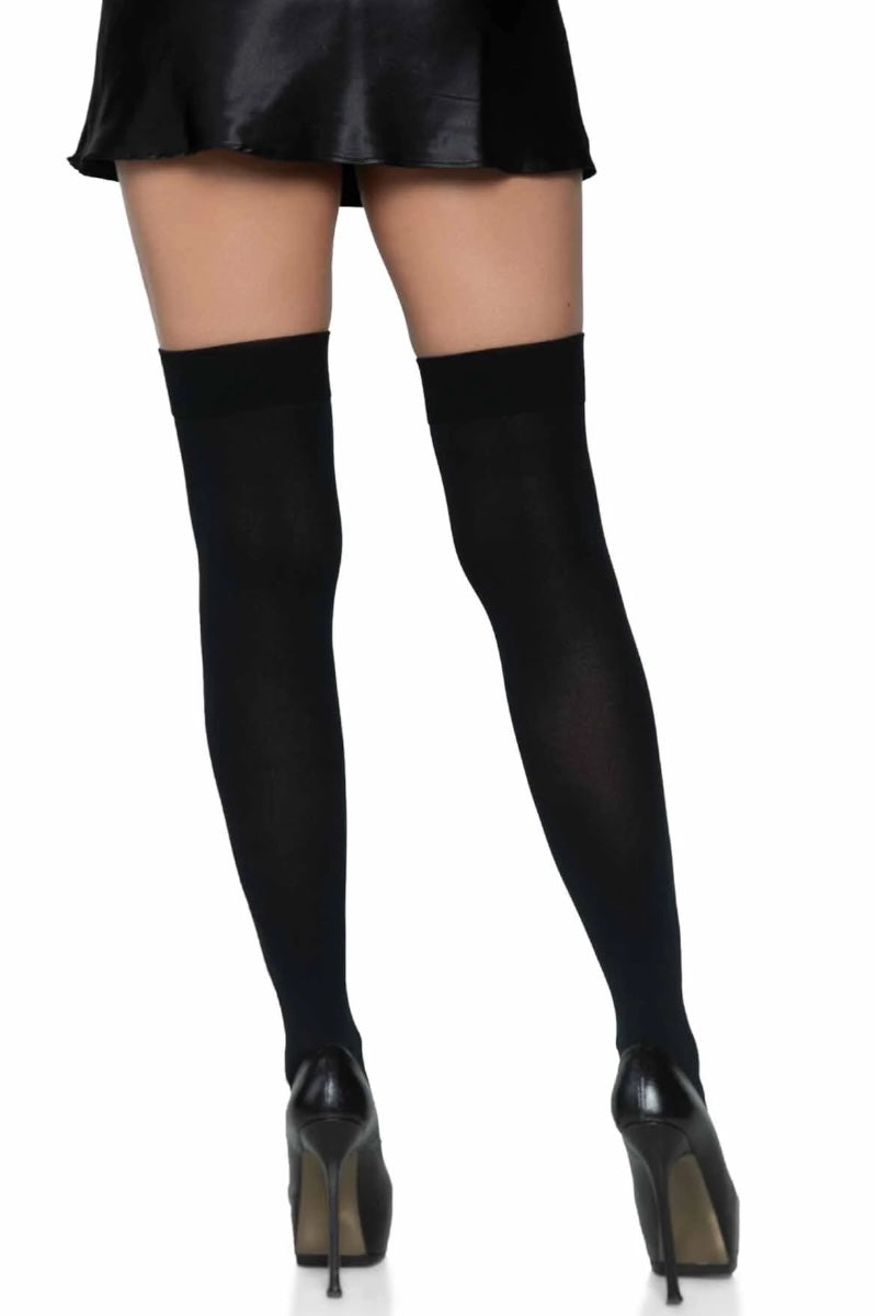 Black thigh-high stockings worn with a black skirt and high heels on a white background