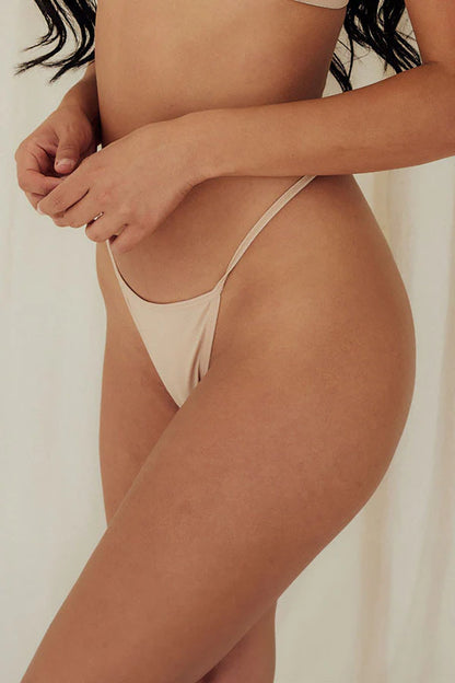 Beige thong bottom worn by a person on a plain background