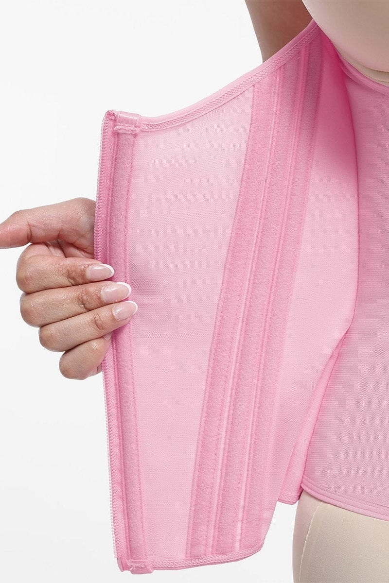 Close-up of a person wearing a pink garment with a white background