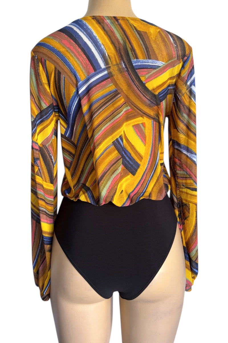 Mannequin wearing a colorful patterned top and black bodysuit on a white background