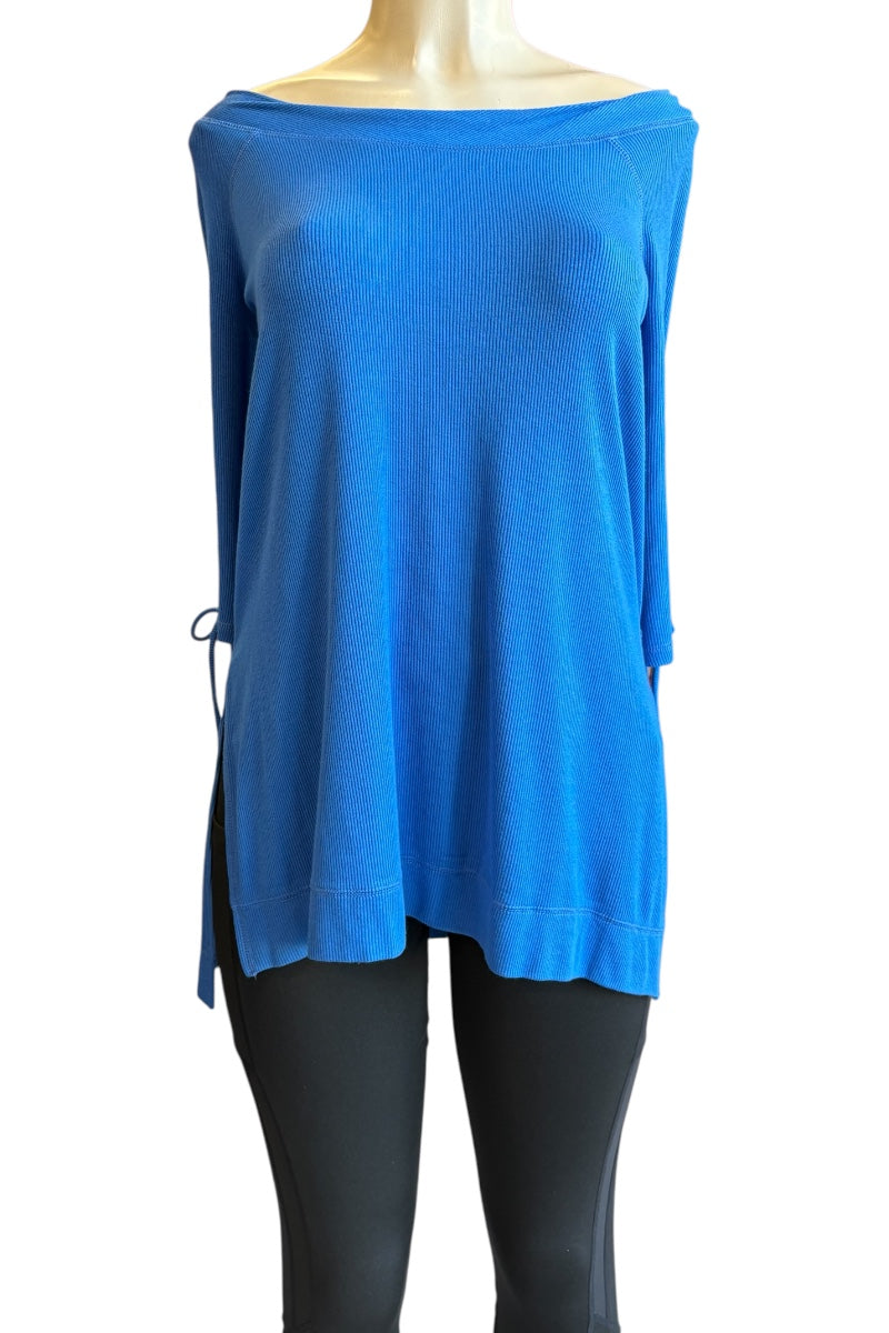 A bright blue off-the-shoulder knit top displayed on a mannequin torso with black leggings against a plain white background.