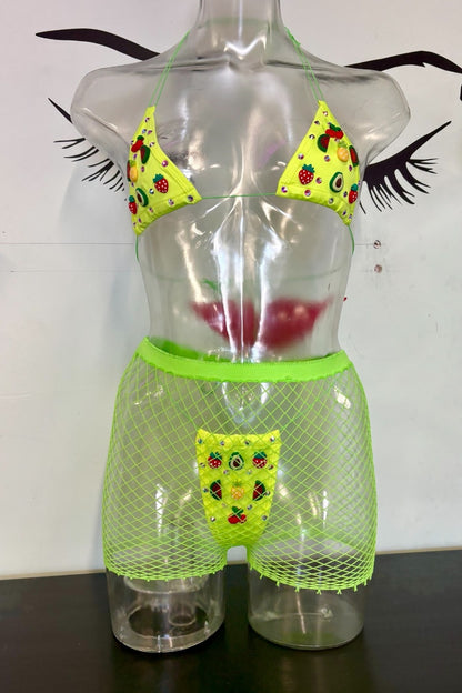 A novelty two-piece bikini set displayed on a clear plastic torso mannequin. The set features a neon green mesh bikini bottom with a matching front pouch and a matching neon green halter top with lime green triangles printed with a colorful fruit pattern.