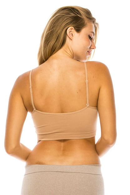 Woman wearing a beige bralette and shorts on a white background