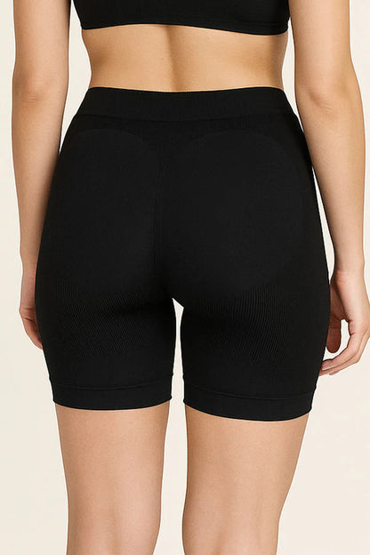 Black high-waisted shorts worn by a person on a beige background