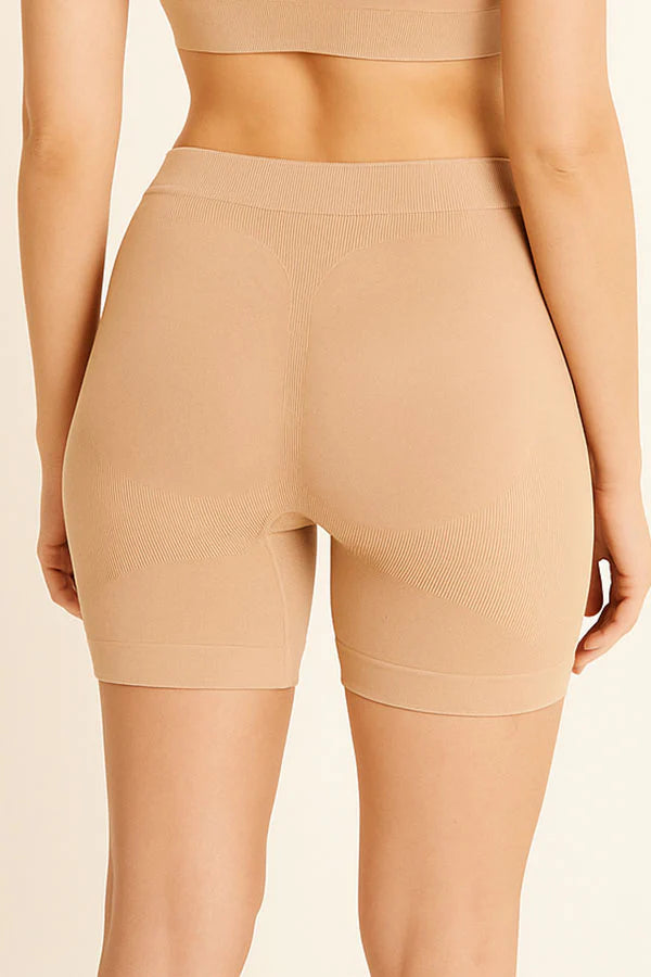 Beige shapewear shorts worn by a person on a beige background