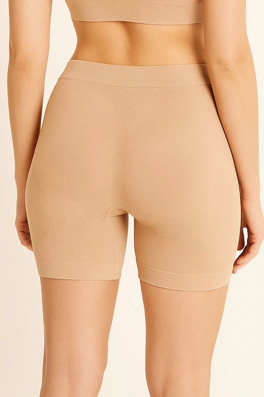 Beige shapewear shorts worn by a person on a beige background