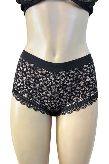 Black lace panties displayed on a beige mannequin torso against a plain white background.