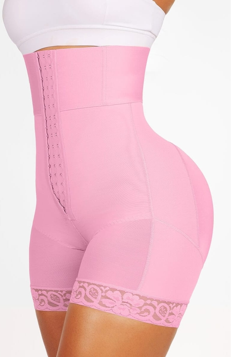 Pink shapewear with lace trim worn by a person on a white background