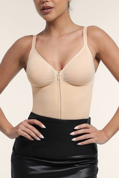 Woman wearing a beige compression garment with a black skirt on a neutral background