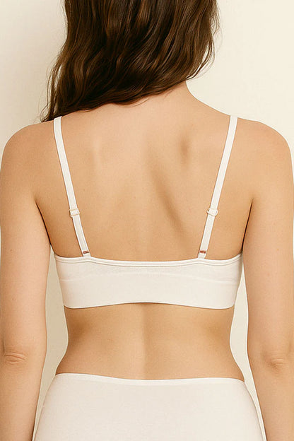 White bra worn by a person on a beige background