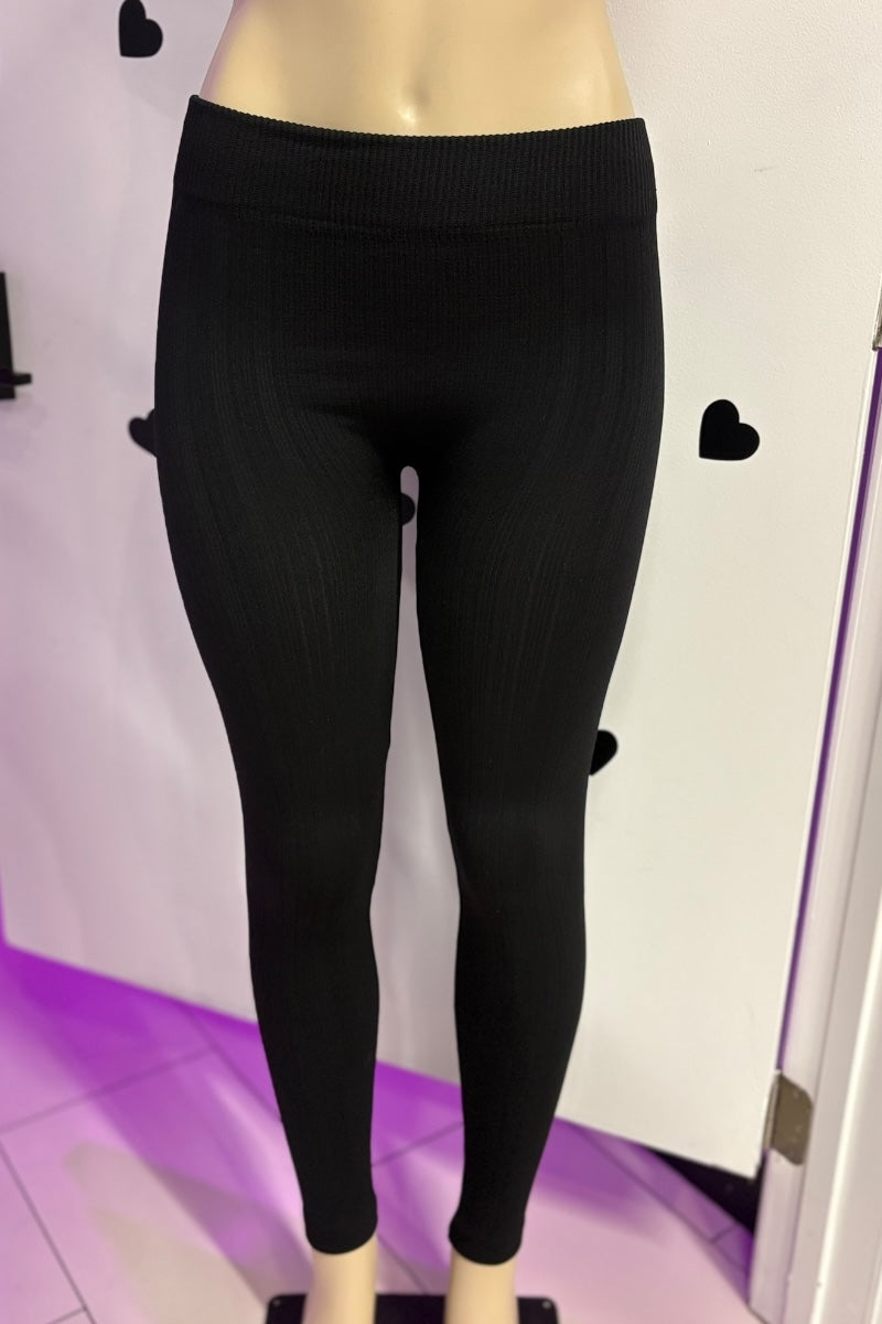 Black leggings on a mannequin against a white background