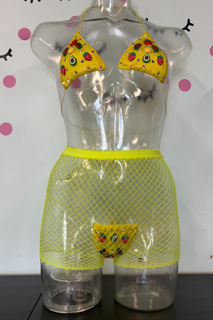 A novelty bikini and mesh underwear set displayed on a clear mannequin torso. The yellow bikini top has fruit charms with red, green, and black details, and the matching yellow mesh shorts include a small yellow thong at the front center.