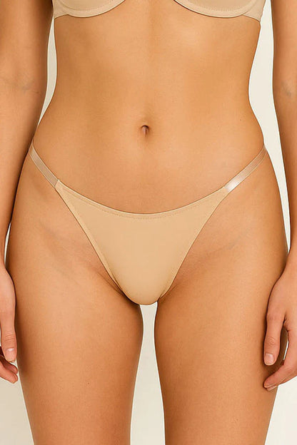 Beige thong worn by a person on a beige background