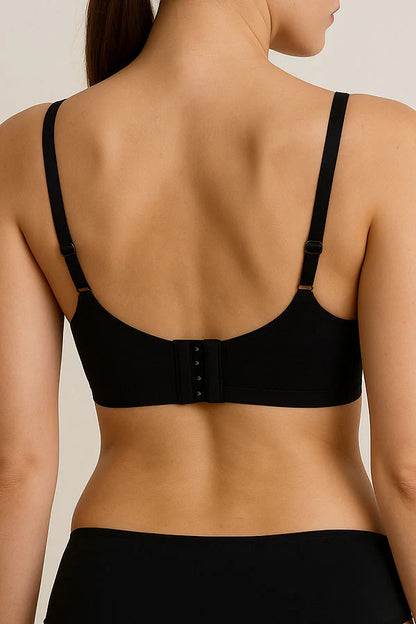 Black bra worn by a model on a beige background