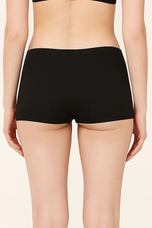 Black high-waisted underwear worn by a person on a beige background