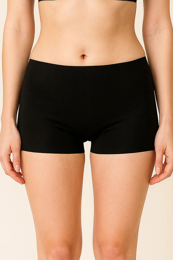 Person wearing black shorts on a beige background