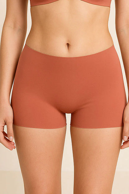 Person wearing a pair of tan-waisted shorts on a beige background