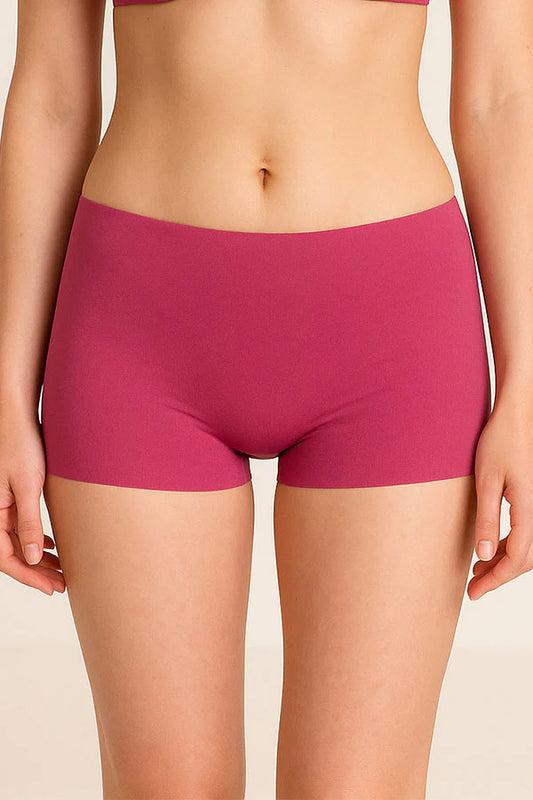 Person wearing a pair of dark fucshia underwear on a beige background