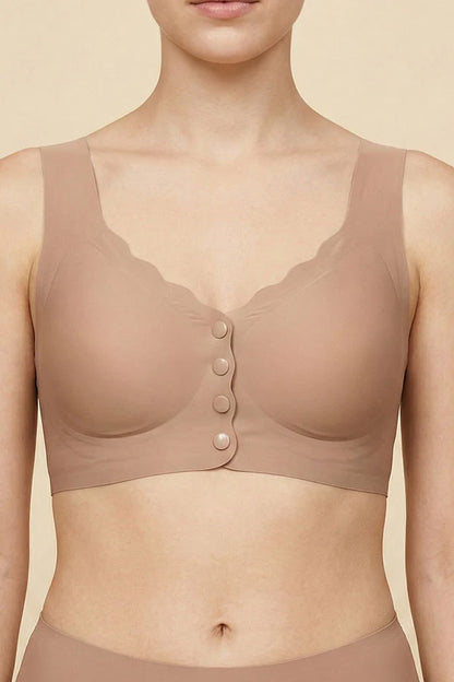 A close-up of a model wearing a seamless, scoop-neck bralette in a warm nude beige color, featuring scalloped edges and a button-up front.