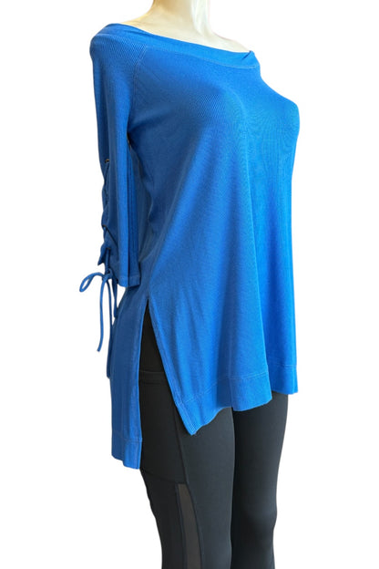 A bright blue off-the-shoulder knit top with side tie closures and a split hem, displayed on a mannequin torso against a plain white background.