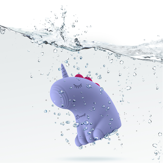 Purple toy with a unicorn horn and pink mane floating in water with bubbles.