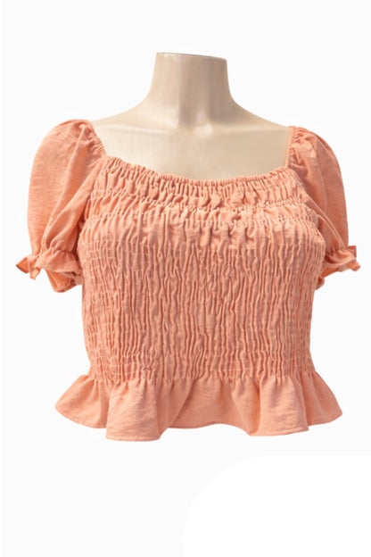 pink coral-colored blouse on a mannequin against a white background