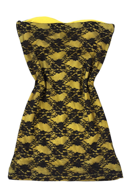 Yellow strapless dress with black lace detailing on a white background
