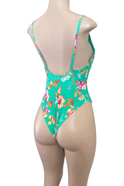 Green floral swimsuit on a mannequin against a white background