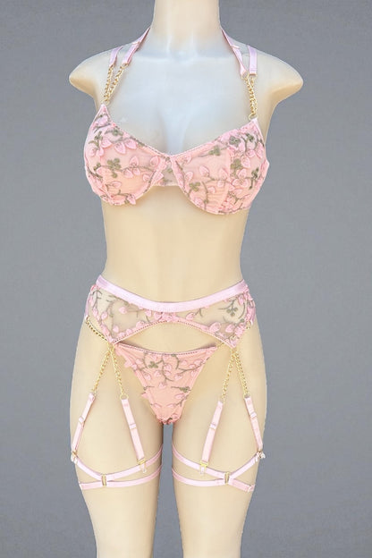 Pink floral lingerie set on a mannequin against a gray background