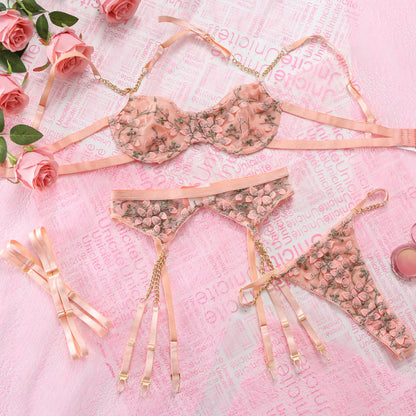 Floral lingerie set on a pink textured fabric background with roses.