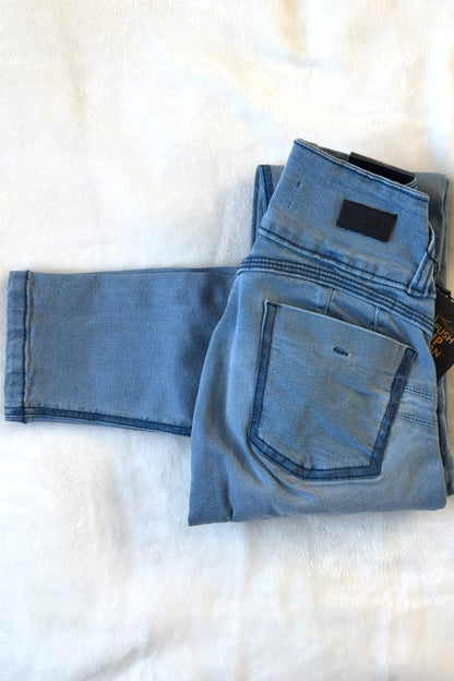 Folded blue jeans with a tag on a white background