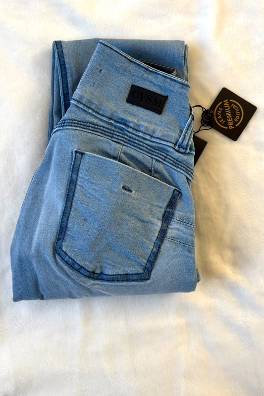 Folded blue jeans with a tag on a white surface