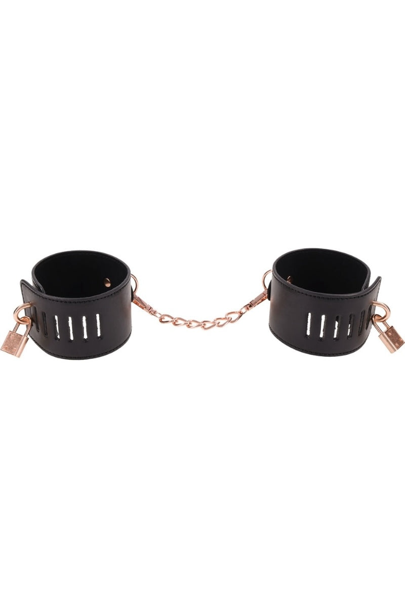 Black leather cuffs with rose gold chain on a white background