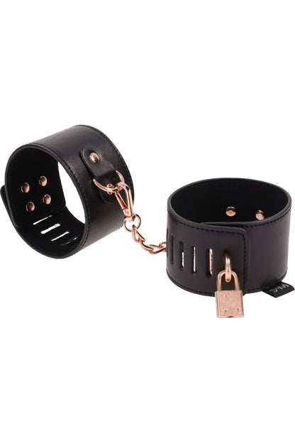 Black leather cuffs with rose gold hardware on a white background