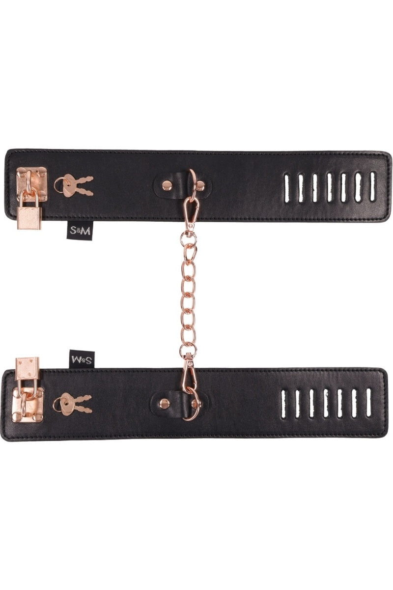 Black leather strap with rose gold hardware and chain on a white background
