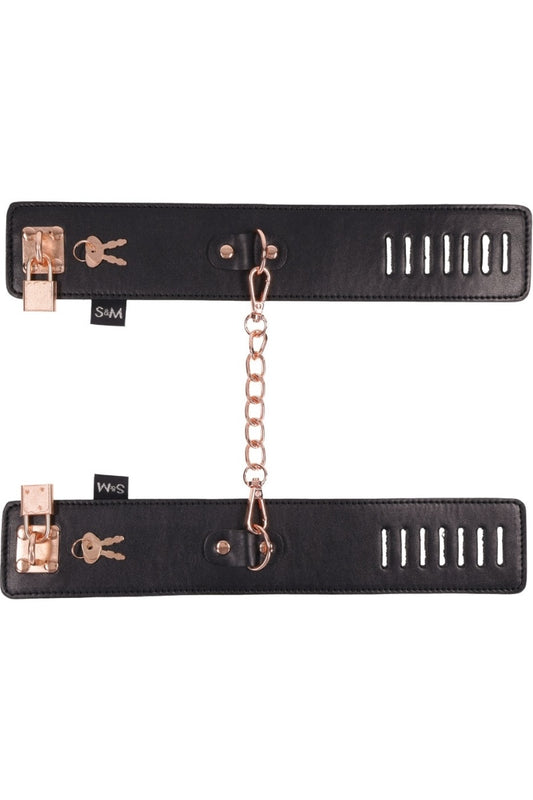 Black leather strap with rose gold hardware and chain on a white background