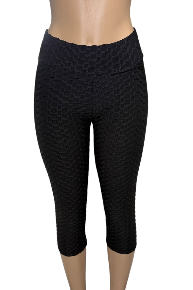 Black capri leggings with a geometric pattern on a white background