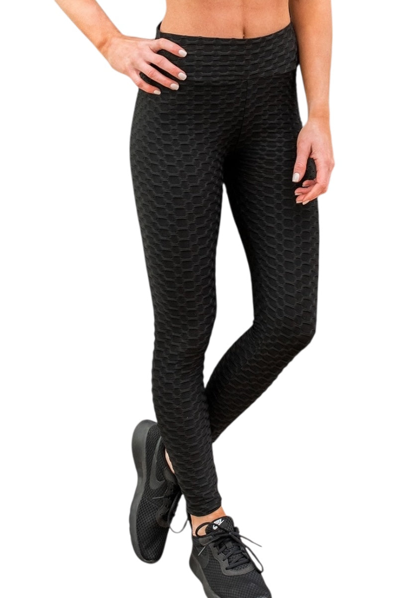 Black textured leggings worn by a person on a white background